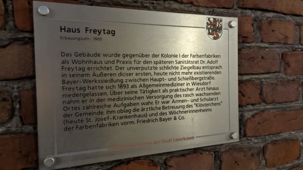 Ein Schild mit einer Erklärung zum "Haus Freytag" an der Hauptstr. 114 in Leverkusen.